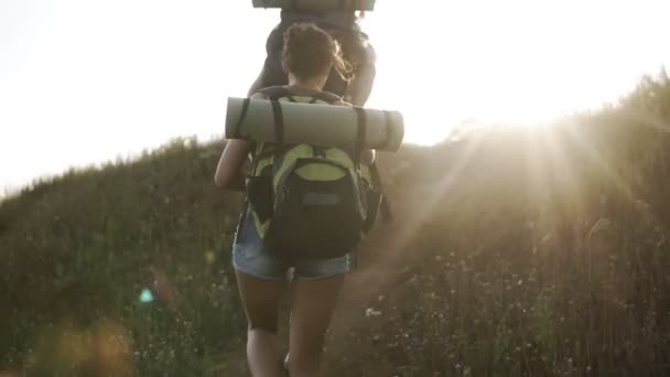 Genç bir çift birlikte hiking arka görüntüleri. Tepenin üst tırmanma. Mutlu, gülümseyerek, zevk. Dostluk, seyahat, kavram hiking — Stok video