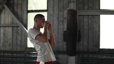 Isınma kadar bir erkek boxer yan görünüm. Cesedini büküm, kalça, yüz önce elele. Traing işlemi. Boks jimnastik salonu