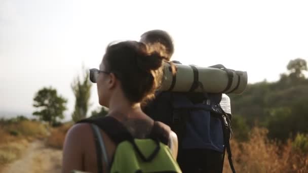 Äventyr, Resor, turism, vandring och människor koncept. Sällsynt footage av ett par hiling kullar tillsammans med ryggsäckar. Morgonsolen — Stockvideo