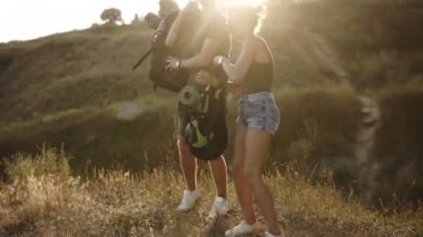 Geri kalan bir tepe üzerinde onların yürüyüş sırasında alarak iki beyaz trevellers. Sırt çantaları alın ve yere, içme suyu froma plastik şişe otur. Görüntüleri kapat