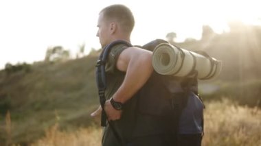 Uzun bir yürüyüş, bir erkekte onun omuz büyük bir sırt çantası alın ve yere koyar. Bir dinlenme sahip. Hiking, aktif dinlenme kavramı