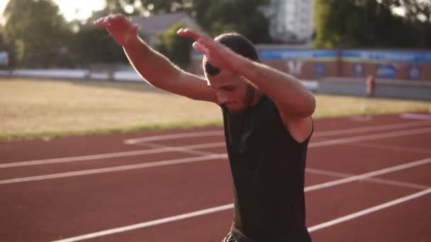 Närbild bilder av en kaukasiska man sträcker armarna och lederna på utomhus stadion. Uppvärmning innan träning — Stockvideo