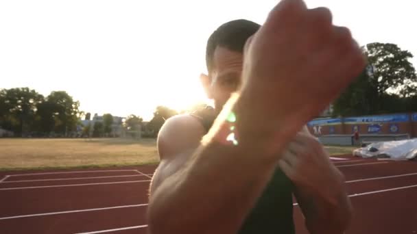 Grabación de cerca de un boxeador enfadado entrenando en el estadio al aire libre. Retrato de un hombre boxeando con oponente invisible, golpeando — Vídeos de Stock