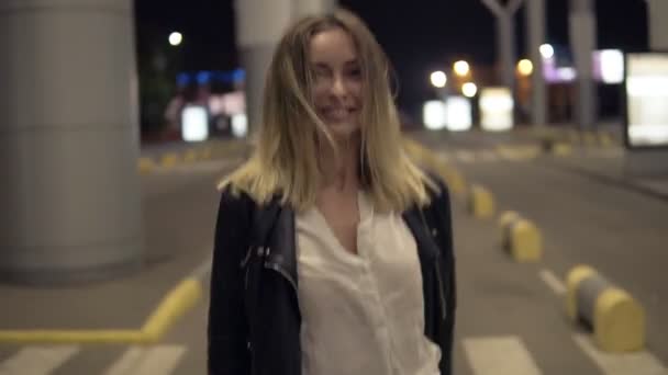 Images de l'arrière d'une belle jeune femme marchant librement par une route vide dans la ville urbaine. Blonde fille souriante, posant pour la caméra — Video