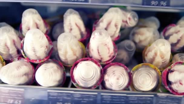 Extremadamente cerca de imágenes de un helado en el estante en el supermercado. Mujer mano-cliente tomar un helado y ponerlo en la cesta de la tienda — Vídeos de Stock