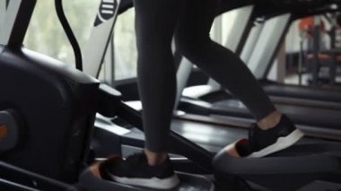 Enerjik, neşeli sportif kız gri tozluk ve siyah sütyen adım eğitmen üzerinde spor salonunda çalışma dışarı. Açık pencerenin fitness kulübünde sarışın kadın