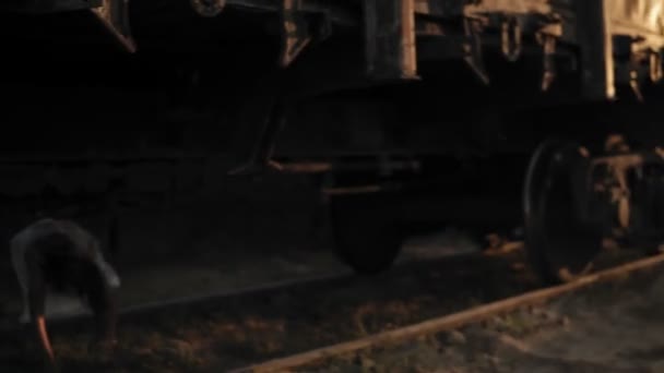 A wounded female zombie in bloody white dress climbs out from under the wagon on the railway and walks away. Halloween, filming, staging concept — Stock Video