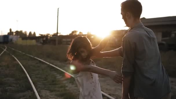 Halloween concepto de filmación de terror. Imagen de espeluznantes zombis masculinos y femeninos al aire libre, de pie en el ferrocarril. Ciudad abandonada y el sol brilla en el fondo — Vídeo de stock