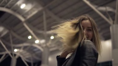 Kamera için poz güzel genç dışında sokakta, gülümseyen kadın. Karanlık. Düşük açılı görüntüleri