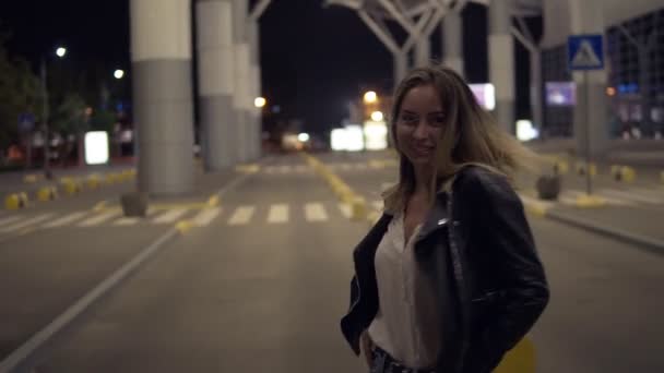 Divertente ragazza bionda cammina tutta la notte per strada urbana, ballando gratis. Donna sorridente in posa per la fotocamera — Video Stock