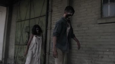 İki zombi ile terk edilmiş bir evde bir arka plan üzerinde yürüyüş mesafesindedir. Yaralı yüz ve kanlı beyaz elbise ve yaralı erkek zombi ile esmer kız açık havada yürüyüş. Hızlanan görüntüleri