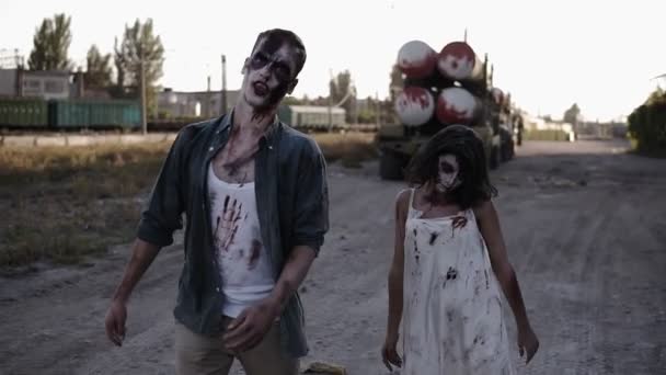 Halloween concepto de filmación de terror. Imagen de espeluznante fantasma masculino y femenino o zombi caminando con la cara herida. Industrial, ciudad abandonada en el fondo — Vídeo de stock