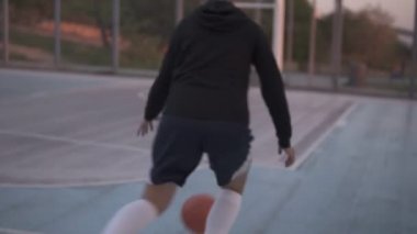 Arka görüntüleri eğitim ve açık havada egzersiz yerel mahkeme bir genç kız basketbol oyuncusu. Top ile top sürme, sıçrayan ve yapmak bir atış