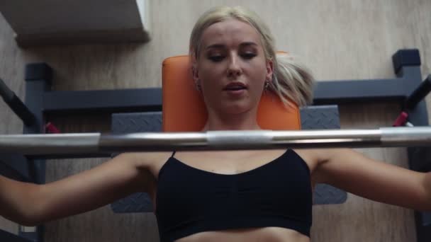 金发运动女孩与完美的健身身体做锻炼艰苦训练与酒吧在倾斜板凳在健身房 从顶部拍摄的画面 — 图库视频影像