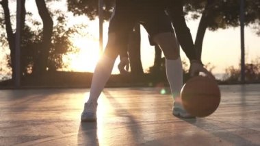 Kadın atlet bacaklar beyaz golf çorap ve ayakkabı görüntülerini kapatın. Kadın baasketball oyuncu zıplayan topu elinden için el., pratik çapraz bacaklar egzersiz. Güneş parlıyor ve arka plan üzerinde