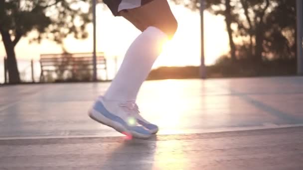 Close-up shot van vrouwelijke basketbal speler benen dribbelen exersice zeer snel zonder bal, training buiten op de lokale rechtbank te doen — Stockvideo