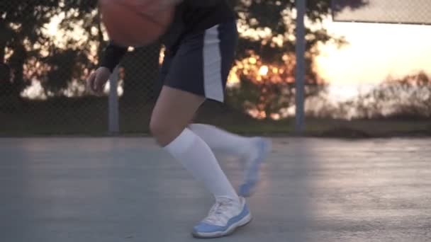 Detailní záběr záběr mladá dívka basketbalista výcvik a cvičení venku na místním hřišti. Driblování s míčem, skákací — Stock video