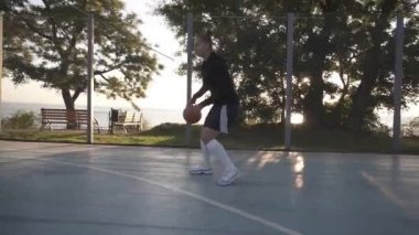 Yan görüntüleri eğitim ve açık havada egzersiz yerel mahkeme bir genç kız basketbol oyuncusu. Top ile top sürme, sıçrayan ve yapmak bir atış