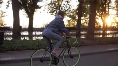 Çekici erkek sabah park veya boulevard bir bisiklet sürme. Genç bir kadın bir trekking bisiklet sürme yan görünüm