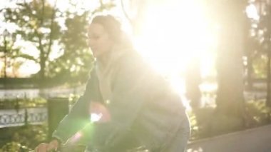 Çekici bir gülümseyen kadın sabah park veya boulevard bir bisiklet sürme görünümünü kapatın. Genç bir kadın bir trekking bisiklet sürme yan görünüm. Güneş parlıyor ve arka plan üzerinde
