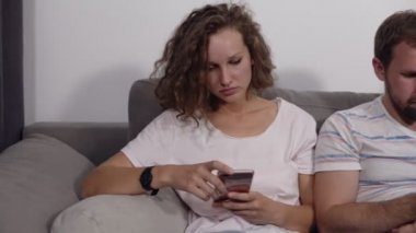 Satır kanepede birlikte oturan farklı genç insanlar cihazlar ile online, beyaz bağımlıları kullanarak onların akıllı telefonlar, digital hayat takıntılı ve gadget'ları kavramı aşırı. Beyaz duvar arka plan