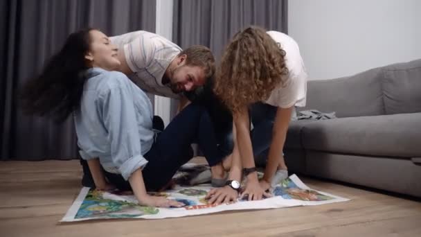 Een groep vrienden spelen in games op de verdieping binnenshuis. Jongeren plezier samen thuis in loft interieur kamer — Stockvideo