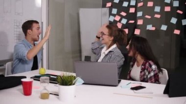 Mutlu başarılı gençlerin iş takım yüksek beşli veren jest olarak gülmek ve başarılarının Projesi'nde tezahürat. Önden görünüm. Ağır çekim