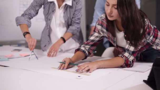 Bedrijf, mensen en teamwork concept - lachende jonge bedrijf team met papieren bijeen in kantoor, maken merken in de project-documenten met behulp van potloden, liniaal. Close-up — Stockvideo