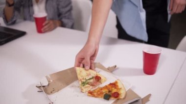 Genç kayıtsızca giyinmiş sonra yeniden personeli görevleri bitirme. Yorgun iş arkadaşlarınızla pizza modern iç ofis içinde eating