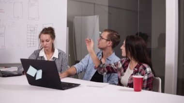 Genç adam gözlük ve iki kadın birbirleri ile bir şey yaratıcı çalışma alanı'ndaki office masada otururken tartışıyor. Esmer kadın whitesheet tahtada işaret onun vizyonu paylaşan