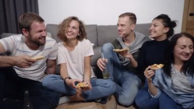 Dostluk, gıda, iç parti zamanı - eğleniyor, kapalı katta oturan ve gülüyor, yeme, içme neşeli beyaz arkadaş semti için pizza. Önden görünüm