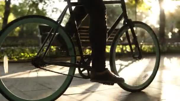 Muž bez tváře nohy chůzi na kole na dlážděné silnici zblízka boční pohled aktivní životní styl. Muž chlapec jde s černým barevné kolo na ulici nebo do zeleného parku. Zdravý život letní Outdoorové aktivity. Pomalu
