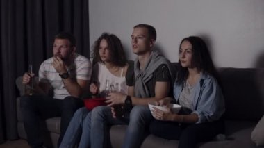 Bira içme patlamış mısır, yeme arkadaşlarım birlikte korku filmi izlemek ve hala çok büyüledi ve korkmuş, otur. Gözleri korkunç resim üzerinden el ile kapatın. Film gecesi