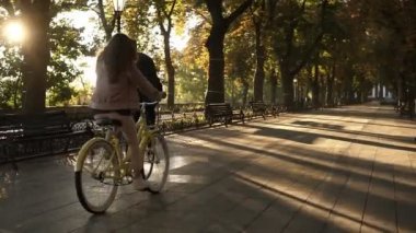 Mutlu genç bir çift veya yaz aylarında boş şehir parkı veya Bulvarı bisiklet sürme arkadaş görünümünde nadir. İnsanlar, eğlence ve yaşam tarzı kavramı