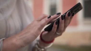 Kız işaret parmağı arka plan ekran smartphone üzerinde bulanık eski şehir siyah manikür eller ve manifatura, kullanma dokunma, arama kadınla görüntüsüdür