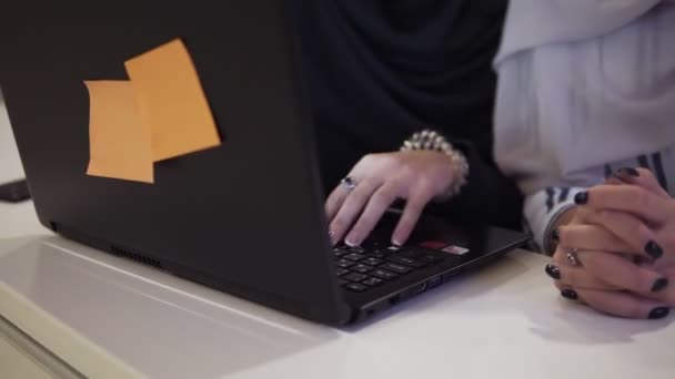 Acelerando el metraje de mujeres de negocios musulmanas felices en hijab en el lugar de trabajo de la oficina o en la sala de conferencias. Dos sonrientes mujer árabe trabajando en el ordenador portátil en el proyecto de inicio juntos, espacio de copia — Vídeos de Stock