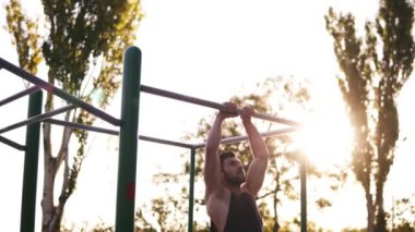 Sakallı fitness adam çalışma dışarı onun kol kasları açık jimnastiği barfiks çekmek Pull-up crossfit egzersiz iş parçası olarak yapıyor. En yüksek çubuğunun altındaki kaldırma