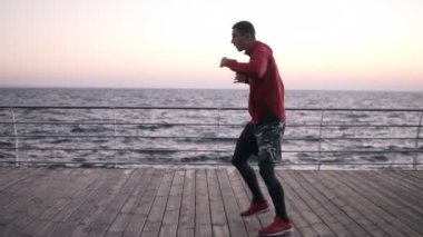 Profesyonel erkek boxer açık eğitim, mücadele duruş, ayakta zor, yapım çevir gövde çalışır. Denize yakın açık havada egzersiz