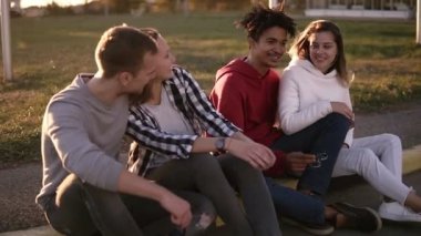 İki genç karışık yarış kartlarının çift sokakta kaldırım üzerinde durur. Açık havada birlikte vakit geçiriyor gülümseyen, mutlu gençler outdors