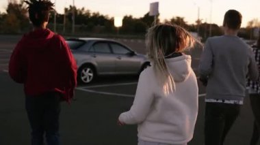 Görünümünde nadir bir multirace trendy genç tarafından çalışan iki çift Park Alışveriş Merkezi bölge ve gümüş renkli araba otur. İki çift birlikte vakit geçiriyor. Akşam alacakaranlık