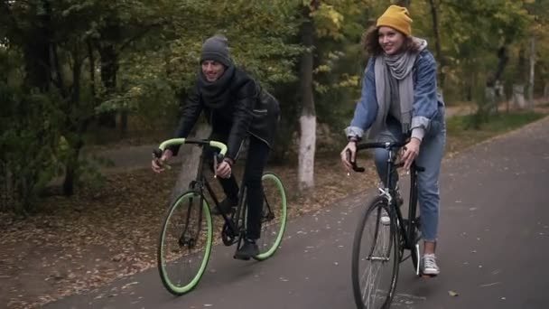 Spokojený úsměv přátel nebo mladý pár na kole na jejich Trekingová kola podzimní parkem na kolech. Muž a žena dohromady na kolech. Pohled zepředu.