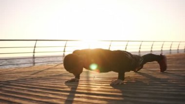 Genç sporcu gönderme yapıyor gürlemesi açık havada üzerinde ahşap froor önünde ile deniz ya da okyanus ups. Sabah güneşi. Fitness ve egzersiz deniz. Spor, eğlence, yaşam kavramı boks