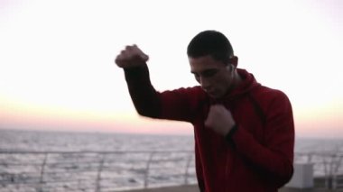 Avrupa erkek boxer avcı eğitim açık havada egzersiz vücut kasları sağlıklı yaşam tarzı ile ve enerji motivasyon - vücut geliştirme deniz kenarında kavramı ile yumruklar.