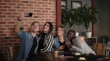 Beyaz adam grup selfie coffeeshop veya işyeri, fotoğraf birlikte Cafe tuğla duvar iç yapım çok ırklı olumlu gençlerin çeşitli arkadaş grubu toplantısında çok etnik gruptan oluşan alarak
