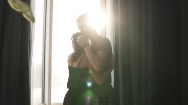 Romantik Çift pijama. Mutlu zaman birlikte. Yakınlık sevgi duygu öpücük sarılarak. Güzel genç yetişkin beyaz kadın ve adam önünde duran objektif mercek parlamaları penceresinde