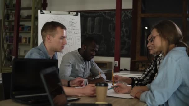 多种族的商务人士团体在现代木制室内办公室开会 年轻的团队拿着业务计划讨论项目的进展 通报过程中 — 图库视频影像