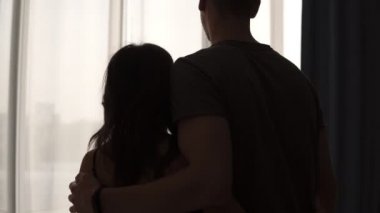 Çift pencere açık perdeleri için yürüyüş seviyorum. Pencerenin önünde sabah yatak odasında emracing ayakta beyaz erkek ve kadın arka görünüm