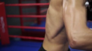 Yakın çekim görüntülerini terli kas gövde mans. Adam siyah spor şort ile nake gövde ve onun koçu ile ringde boks eldivenleri trenler darbeler toprotected gövde yerine getirir. Kavramı