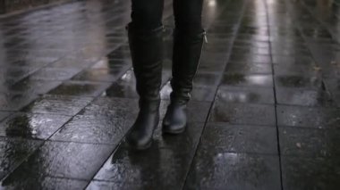 Kadın kaldırım sokak yürüyüş sonbahar Park'ta yürüyüşe. Bacak ve ayakkabı görünümü kapatın. Zarif Bayan giyim siyah çizmeler. Sonbahar hava, rayny, yol ıslak. Önden görünüm
