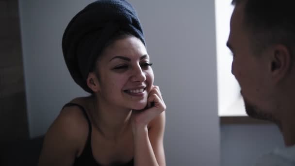 Hermosa mujer después de la ducha con toalla oscura en la cabeza teniendo conversación con su novio en frente. Pareja joven en la cocina desayunan. Buen tiempo juntos. — Vídeos de Stock